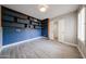 Bedroom with blue tiled wall with shelving, complemented by wood-look tile flooring at 6533 N 7Th Ave # 18, Phoenix, AZ 85013