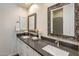 This primary bathroom features dual sinks, decorative mirrors, and updated lighting and countertops at 654 E County Down Dr, Chandler, AZ 85249