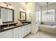 A well-lit bathroom with dual sinks, stylish mirrors, and modern finishes throughout the space at 654 E County Down Dr, Chandler, AZ 85249