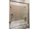 Well-maintained bathroom boasting tiled shower and tub with glass doors, upgraded fixtures, and modern finishes at 654 E County Down Dr, Chandler, AZ 85249