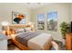 Inviting bedroom with a wood bed frame, bedside lamps, and large windows offering serene outdoor views at 654 E County Down Dr, Chandler, AZ 85249