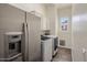 Bright laundry room with stainless steel refrigerator and front loading washer and dryer at 654 E County Down Dr, Chandler, AZ 85249