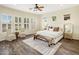 Bright main bedroom with plush king bed, bench, soft carpet, and sunlit windows with views of the neighborhood at 654 E County Down Dr, Chandler, AZ 85249