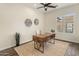 This home office features a wooden desk, neutral decor, and a sunlit window, perfect for remote work at 654 E County Down Dr, Chandler, AZ 85249