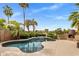 Backyard pool with a unique waterfall feature, mature landscaping, and an outdoor fireplace at 654 E County Down Dr, Chandler, AZ 85249