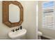 Pedestal sink and framed mirror accent the powder room; natural light from window at 654 E County Down Dr, Chandler, AZ 85249
