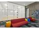 A well-lit glass-walled squash court with colorful seating and modern art at 7180 E Kierland Blvd # 814, Scottsdale, AZ 85254