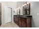 Bathroom featuring dual sinks, dark wood cabinets and a private door at 7456 W Irma Ln, Glendale, AZ 85308