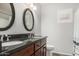 Bathroom featuring dual sinks, dark wood cabinets and a tiled floor at 7456 W Irma Ln, Glendale, AZ 85308