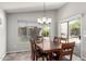 Dining room with window and sliding door to backyard, complete with a wood dining set at 7456 W Irma Ln, Glendale, AZ 85308
