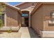 View of the home's front entrance with a covered entryway and attractive desert landscaping at 7456 W Irma Ln, Glendale, AZ 85308
