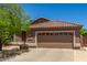 Charming single-story home with a two-car garage, desert landscaping, and a terracotta-tiled roof at 7456 W Irma Ln, Glendale, AZ 85308