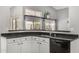 Well-appointed kitchen with white cabinets, black countertops, and stainless steel faucet at 7456 W Irma Ln, Glendale, AZ 85308