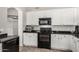 Bright kitchen with white cabinets, black appliances, and a convenient layout at 7456 W Irma Ln, Glendale, AZ 85308