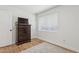 Bright bedroom featuring hardwood floors, a large dresser, and a window with blinds at 7607 N 17Th Ave, Phoenix, AZ 85021