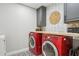 Modern laundry room with red washer/dryer set, eye catching wallpaper, and stylish tile flooring at 7607 N 17Th Ave, Phoenix, AZ 85021