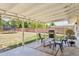 Covered patio with a grill, table, and chairs overlooking a spacious backyard with a trampoline at 7607 N 17Th Ave, Phoenix, AZ 85021
