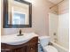 Well-lit bathroom features a sink with dark wood cabinets and a shower-tub combo at 822 E Ross Ave, Phoenix, AZ 85024