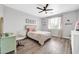 Bedroom featuring light wood floors, modern decor, a ceiling fan and a window at 9034 W Eagle Talon Dr, Peoria, AZ 85383