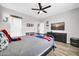 Bedroom featuring light wood floors, ceiling fan, TV and decorative shelves at 9034 W Eagle Talon Dr, Peoria, AZ 85383