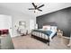 Bedroom boasts a dark accent wall, modern fan, and a vanity desk next to the black metal bed frame at 9034 W Eagle Talon Dr, Peoria, AZ 85383