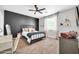 Bedroom featuring a dark accent wall, bright window with curtains, and sleek furniture at 9034 W Eagle Talon Dr, Peoria, AZ 85383