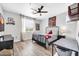 Bedroom features a light wood floor, ceiling fan, and superhero themed decor at 9034 W Eagle Talon Dr, Peoria, AZ 85383