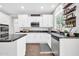 Well-lit kitchen with white cabinets, dark countertops, stainless steel appliances, and dark flooring at 9034 W Eagle Talon Dr, Peoria, AZ 85383