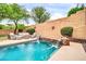 Inviting pool with a cascading waterfall feature, set amidst lush landscaping and patio furniture at 9034 W Eagle Talon Dr, Peoria, AZ 85383