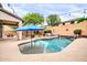 Backyard pool with an umbrella, desert landscaping, and an outdoor seating area at 9034 W Eagle Talon Dr, Peoria, AZ 85383