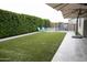 Beautiful backyard showcasing a pool with slide, blue Adirondack chairs, lush privacy hedge, and tiled patio at 9187 W Parkside Ln, Peoria, AZ 85383