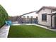 Well-maintained backyard featuring a pool with slide, seating, artificial turf, and mature privacy hedge at 9187 W Parkside Ln, Peoria, AZ 85383