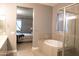 Luxurious bathroom with a soaking tub, glass-enclosed shower, and elegant tile work at 9187 W Parkside Ln, Peoria, AZ 85383