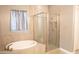 Elegant bathroom featuring a soaking tub, a glass-enclosed shower, and modern fixtures at 9187 W Parkside Ln, Peoria, AZ 85383
