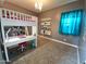 View of bedroom featuring bunk bed with desk and shelving, modern lighting, and window with decorative curtain at 9187 W Parkside Ln, Peoria, AZ 85383