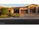 Inviting home exterior with a stone facade, manicured lawn, and a spacious three-car garage at 9187 W Parkside Ln, Peoria, AZ 85383