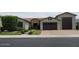 Charming single-story home with a stone facade, well-manicured lawn, and a three-car garage at 9187 W Parkside Ln, Peoria, AZ 85383