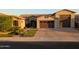 Charming single-Gathering home featuring a brick driveway, three-car garage, and well-maintained landscaping at 9187 W Parkside Ln, Peoria, AZ 85383