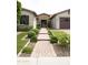 Beautiful home with a stone walkway leading to the front door and well-maintained landscaping at 9187 W Parkside Ln, Peoria, AZ 85383