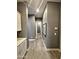 Hallway with gray paint, modern flooring, baseboards, wall art, and access to other rooms at 9187 W Parkside Ln, Peoria, AZ 85383