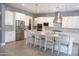 Modern kitchen featuring white cabinetry, stainless steel appliances, and a large center island with bar seating at 9187 W Parkside Ln, Peoria, AZ 85383