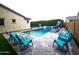 Relaxing pool area with a slide, privacy hedge, and comfortable blue Adirondack chairs for poolside lounging at 9187 W Parkside Ln, Peoria, AZ 85383