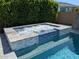 Inviting in-ground pool featuring a built-in hot tub, a stylish tiled surround, and a privacy hedge at 9187 W Parkside Ln, Peoria, AZ 85383