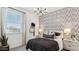 Cozy bedroom featuring modern light fixture, textured wallpaper and bright windows at 9815 S 11Th St, Phoenix, AZ 85042