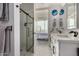 Modern bathroom with a glass-enclosed shower, double vanity, and an open doorway to a bedroom with city views at 1 E Lexington Ave # 1108, Phoenix, AZ 85012