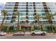 The luxurious building has a modern glass exterior with palm trees in front at 1 E Lexington Ave # 1108, Phoenix, AZ 85012