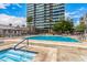 Large community pool and hot tub surrounded by lounge chairs and palm trees for relaxation at 1 E Lexington Ave # 1108, Phoenix, AZ 85012