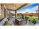Relaxing covered patio with comfortable seating and a cozy fire pit overlooking the well maintained backyard at 10224 E Talameer Ave, Mesa, AZ 85212