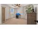 Bright bedroom with a ceiling fan, dual windows with great natural light, and a functional home office setup at 10224 E Talameer Ave, Mesa, AZ 85212