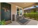 Inviting front porch with seating area, stylish outdoor rug, and decorative front door with a wreath at 10224 E Talameer Ave, Mesa, AZ 85212